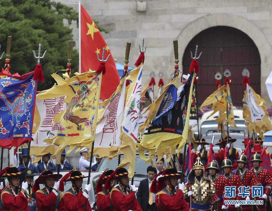 7月3日，韩国总统朴槿惠在青瓦台总统府举行隆重仪式，欢迎中国国家主席习近平对韩国进行国事访问。这是习近平的车队在身着民族服装的韩国礼仪队伍引导下驶入青瓦台。新华社记者丁林摄  